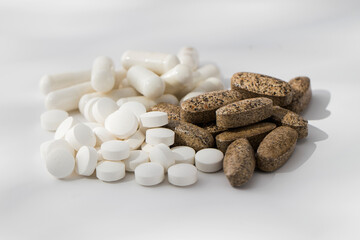 A variety of pills and vitamins in a pile on a white background. Medicine, medicines. 