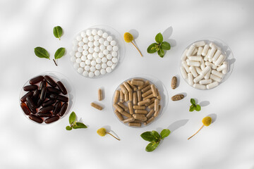 Various vitamins, tablets and dietary supplements with natural formulations on a white background.