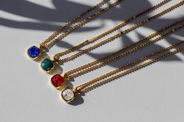 Necklace gold vintage chain precious colored shiny zircon stones. Accessory of turquoise, white, purple, violet, lavender, pink, green stones. yellow chain jewelry. macro, photo on white background - obrazy, fototapety, plakaty