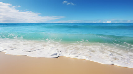 Fototapeta na wymiar Ocean waves gently lapping on a tropical beach with clear blue sky.