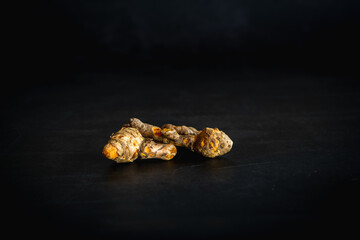 fresh turmeric root on a black background