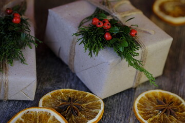 Christmas gifts decorated with a branch natural branch on a wooden old background