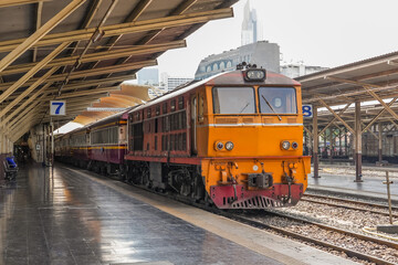 Locomotive diesel train with passenger carriages at the station before departure.