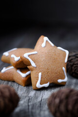 Christmas cookies in the shape of a star with white icing on old wooden background. Vertical image.