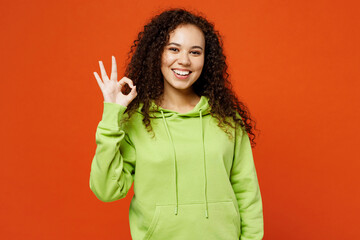 Young smiling cheerful fun woman of African American ethnicity she wears green hoody casual clothes...