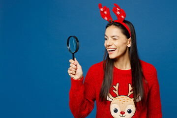 Merry cheerful young Latin woman wear red Christmas sweater decorative fun deer horns on head...