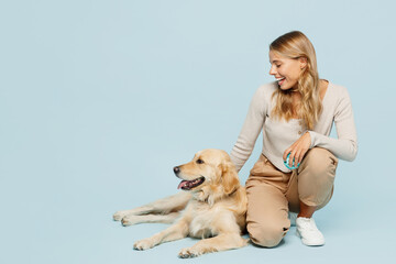 Full body smiling satisfied young owner woman wear casual clothes kneeling hug cuddle embrace her...