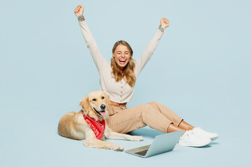Full body winner young owner IT woman wears casual clothes sit near her best friend retriever dog...