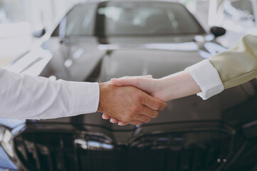 Cropped close up photo of man customer male buyer client shake salesman female hand arm choose auto...