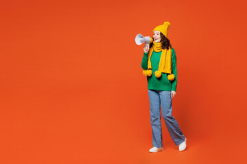 Full body young woman she wear green knitted sweater yellow hat scarf hold in hand megaphone scream...