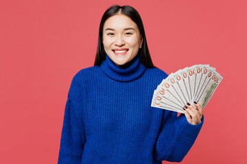 Young woman of Asian ethnicity she wear blue sweater casual clothes hold in hand fan of cash money...