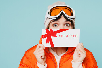 Skier young woman wears windbreaker jacket hat ski goggles mask hold cover mouth store gift coupon...
