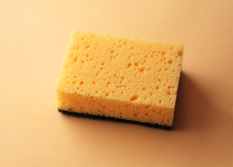 Cleaning sponge on a peach fuzz color background. Cleaning concept, cleaning service.Top view