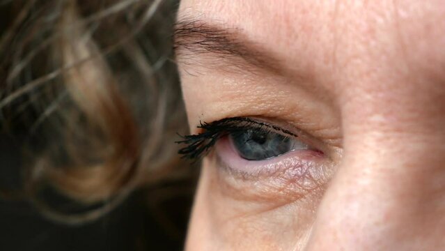 middle aged female's eye with drooping eyelid making eyebrow makeup. Ptosis is a drooping of the upper eyelid, lazy eye. Cosmetology and facial concept, first wrinkles