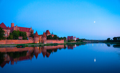 Naklejka na ściany i meble Marienburg castle the largest medieval brick castle in the world in the city of Malbork evening view at night