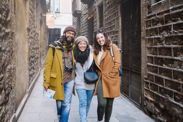Tourist friends walking historical old town, happy visiting Europe and enjoying winter vacations 