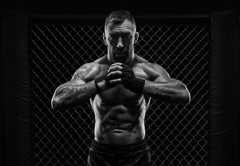The dramatic black white image of the MMA fighter. Photography in a real octagon. Brutal fighter