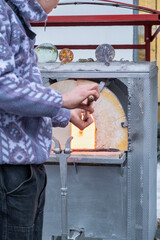 the process of immersing a glass blank on a metal pole into a red-hot furnace