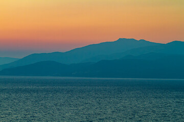 Aegean sea and mountains illuminated by summer sunset