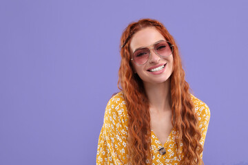 Stylish young hippie woman in sunglasses on violet background, space for text