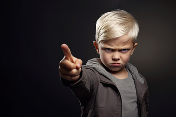 Angry child pointing his finger. The concept of child aggression, anger and hatred - obrazy, fototapety, plakaty