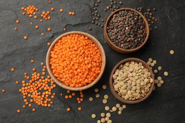 Different types of lentils in bowls on grey textured table, flat lay