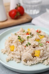 Delicious barley porridge with vegetables and microgreens on table, closeup