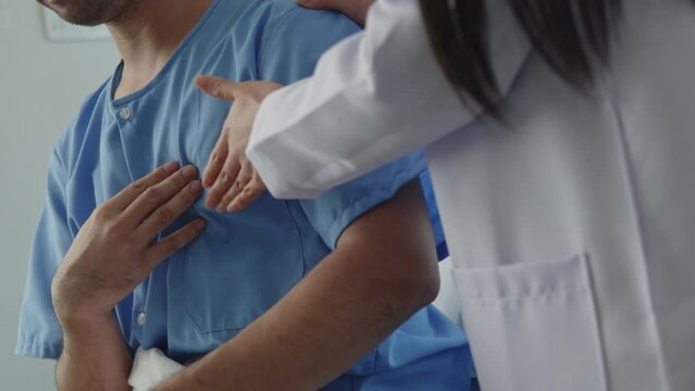 Doctor  listening lungs and test rise patient hand with chest pain and had a risk for heart attack in hospital.