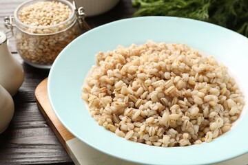 Delicious fresh pearl barley on wooden table, closeup