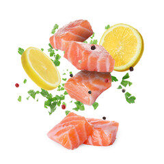 Fresh salmon pieces, spices and lemon slices falling on white background