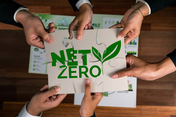 Top view cohesive group of business people forming jigsaw puzzle pieces in net zero icon symbol as...