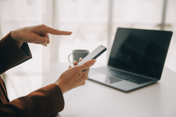 Attractive smiling young asian business woman work at home office, Asian woman working on laptop computer holding tablet.