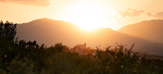 a beautiful golden hour shining on an authentic hilltop village, located in italy.