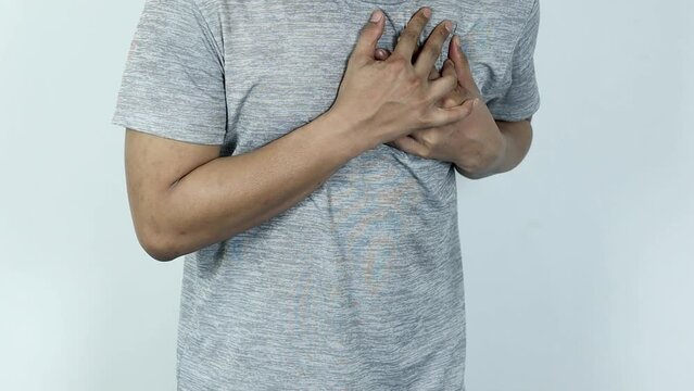 asian man pressing chest with painful expression. Severe heartache, having a heart attack or painful cramps, heart disease.