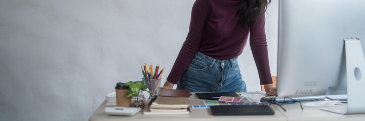 Graphic designer freelance women reading data to thinking creative ideas for logo brand while typing on computer and working to designing about graphic design with technology equipment in home studio