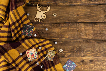 Wooden Background with yellow an d brown plaid with christmas attributes, giftcards, deer, stars,...