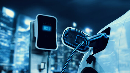 Electric car plugged in with charging station to recharge battery with electricity by EV charger...