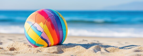 Colorful volleball ball lying on sunny beach near sea 