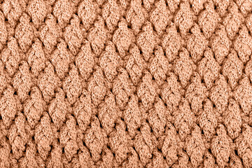 Texture of knitted woolen fabric for wallpaper toned with peach fuzz color of the year 2024