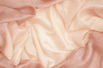 Crumpled silk fabric, peach color, soft texture, pastel textile background