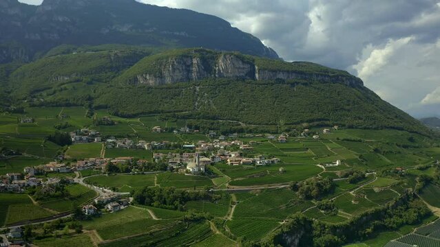 Aerial drone view of Cortaccia village and iconic church on the Alps mountain landscape region in Italy