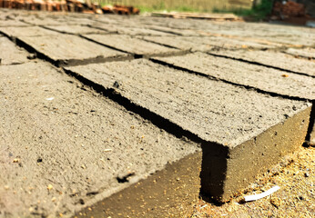 Production of homemade bricks from a mixture of clay and straw in Tegal city, Indonesia. Mudbricks are dried in the sun. Selective focus.