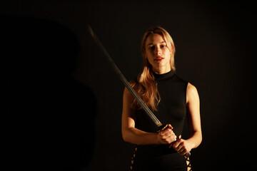 Low key portrait of woman with a katana sword