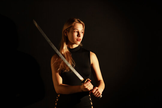 Low key portrait of woman with a katana sword