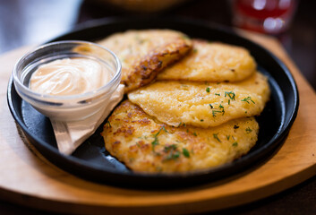 Fried grated potato pancakes with sour cream