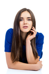 Naklejka premium Charming young woman holding hands neat to her face posing over white background