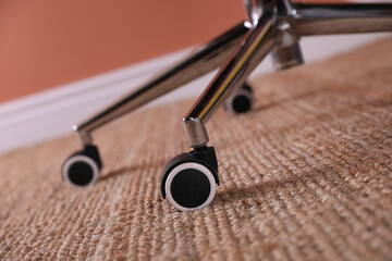 Modern office chair with wheels on floor, closeup