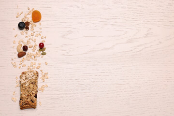 Tasty granola bar and ingredients on white wooden table, top view. Space for text