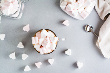 Sweet cocoa with heart-shaped marshmallows in a cup on the table. Top view