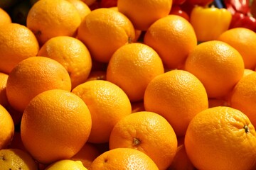 Heap of fresh oranges on counter at market, closeup